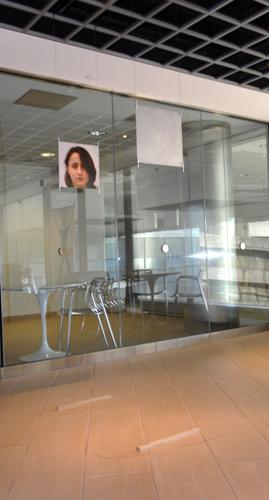 Photograph of a face, displayed on a glass door.