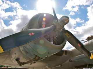 An aircraft engine with blue sky and white clouds in the background An aircraft engine with blue sky and white clouds in the background