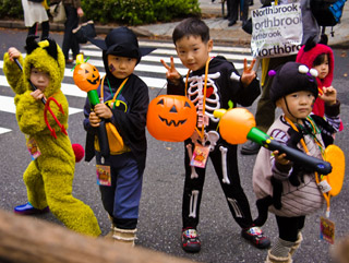 Four small children, two holding jack-o'-laterns, pose in their Halloween costumes. Four small children, two holding jack-o'-laterns, pose in their Halloween costumes.