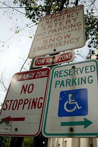 Photograph of four street signs: Reserved Parking, No Stopping, Tow Away Zone, and No Parking. Photograph of four street signs: Reserved Parking, No Stopping, Tow Away Zone, and No Parking.