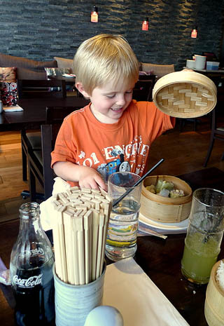 A photograph of a child eating dim sum. A photograph of a child eating dim sum.