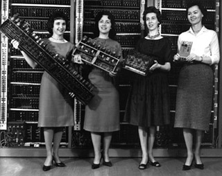 Photo of four women holding computer boards. Photo of four women holding computer boards.