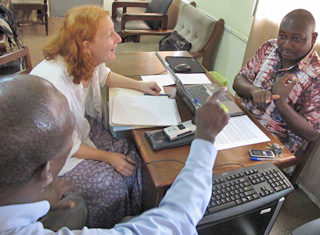 A translator and interview subject sign to one another as an anthropologist watches. A translator and interview subject sign to one another as an anthropologist watches.
