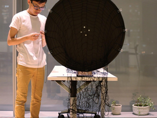 Student spinning yarn on a weaving wheel. Student spinning yarn on a weaving wheel.