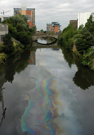 Photo of oil sheen on river going through city. Photo of oil sheen on river going through city.