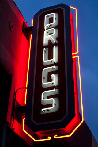 A neon sign that says "DRUGS". A neon sign that says "DRUGS".