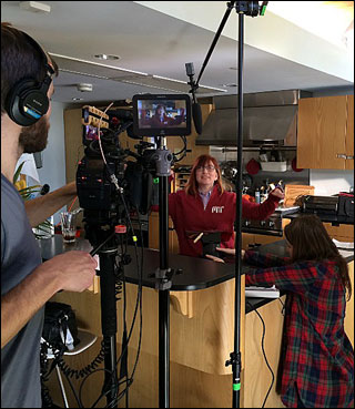A woman in an MIT shirt being filmed by a crew. A woman in an MIT shirt being filmed by a crew.