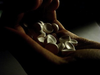 Photo of hand holding many white pills. Photo of hand holding many white pills.