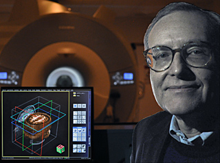 Photo of Professor Gabrieli sitting next to a computer display of human brain images, with fMRI scanner in the background. Photo of Professor Gabrieli sitting next to a computer display of human brain images, with fMRI scanner in the background.