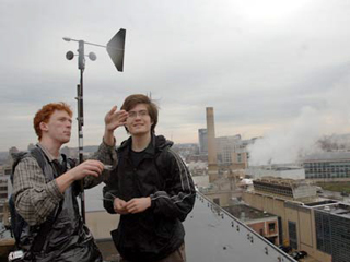 Photo of members of Team Wind with a wind turbine behind them. Photo of members of Team Wind with a wind turbine behind them.