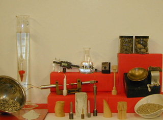 A photo of various equipment- like a caliper, scale, beaker with sample materials like pieces of wood, metal and stone. A photo of various equipment- like a caliper, scale, beaker with sample materials like pieces of wood, metal and stone.