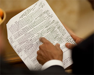A photo of President Obama's hand pointing to a draft of his healthcare speech, which is marked up with edits. A photo of President Obama's hand pointing to a draft of his healthcare speech, which is marked up with edits.
