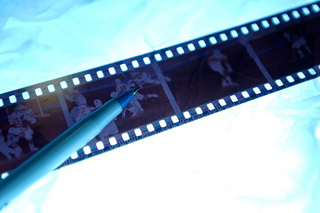 A photograph of a pen sitting on top of photo negatives, lit from behind. A photograph of a pen sitting on top of photo negatives, lit from behind.