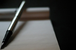 Photograph of pen and writing pad. Photograph of pen and writing pad.
