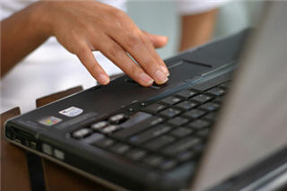 Woman's hand over a laptop touch pad. Woman's hand over a laptop touch pad.