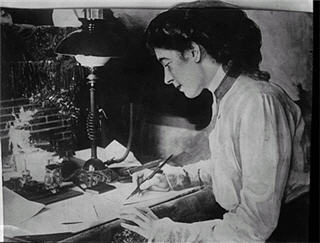 Black and white photo of woman writing at a desk Black and white photo of woman writing at a desk