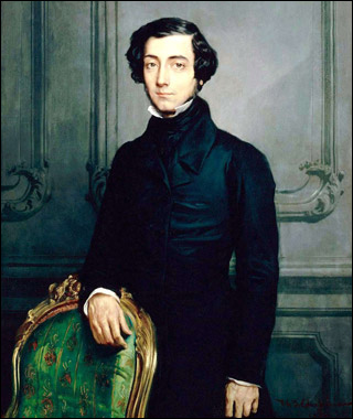 A slim smartly-dressed young man, with wavy black hair, stands behind an ornate chair. A slim smartly-dressed young man, with wavy black hair, stands behind an ornate chair.