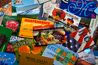 A pile of brightly colored cards from different states, similar to credit cards. A pile of brightly colored cards from different states, similar to credit cards.