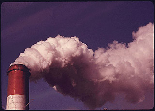 A photograph of smoke billowing out of a stack at a power station. A photograph of smoke billowing out of a stack at a power station.