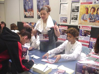 A photo of people at a sign-up table. A photo of people at a sign-up table.