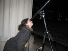 Photo of a student looking through the telescope at the moon.