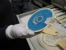 Photo of students holding and viewing circular slide rules in the MIT Museum.