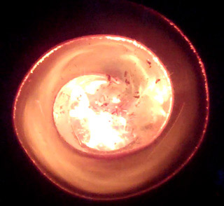 Photo of a metal spiral with flame traveling around it. Photo of a metal spiral with flame traveling around it.