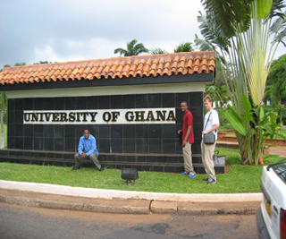 A photograph of three MIT students at the entrance of the University of Ghana. A photograph of three MIT students at the entrance of the University of Ghana.