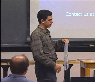 Student showing a clear plastic bag with hose and nozzle. Student showing a clear plastic bag with hose and nozzle.