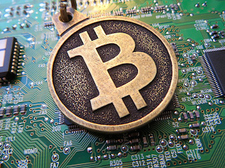 Bitcoin keychain over circuit board. Bitcoin keychain over circuit board.