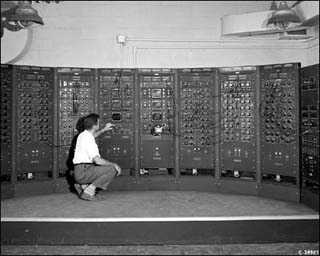 A scientist squatting in front of a mainframe computer. A scientist squatting in front of a mainframe computer.