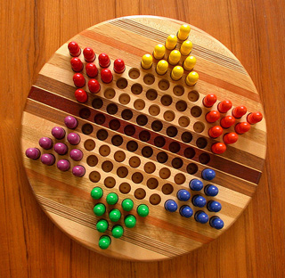 A star shaped board with different colored pegs in each corner. A star shaped board with different colored pegs in each corner.
