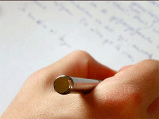 A hand holding a pen writes out words on a piece of paper. A hand holding a pen writes out words on a piece of paper.