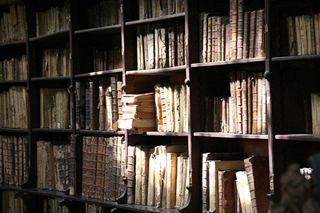 Shelves of old books in partial sunlight. Shelves of old books in partial sunlight.