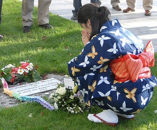 A photo of a woman in a kimono at a memorial for the bombing or Hiroshima and Nagasaki. A photo of a woman in a kimono at a memorial for the bombing or Hiroshima and Nagasaki.