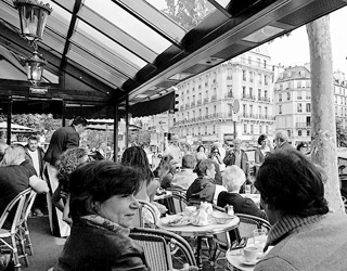 Diners overlook a bustling street at an open air café in Paris. Diners overlook a bustling street at an open air café in Paris.