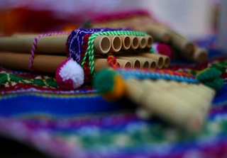 Photograph of a pan flute on a colorful blanket. Photograph of a pan flute on a colorful blanket.