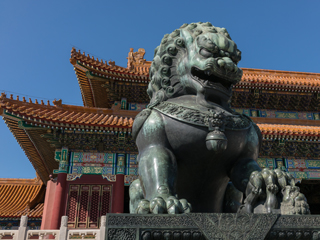 A Chinese lion sculpture in front of a Chinese palace-like building A Chinese lion sculpture in front of a Chinese palace-like building