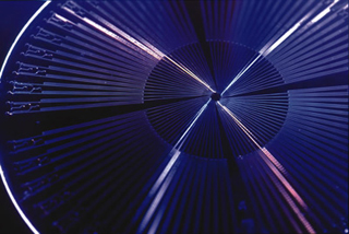 A photo of fast-moving colored lights which appear to be spinning in a circle above a machine. A photo of fast-moving colored lights which appear to be spinning in a circle above a machine.