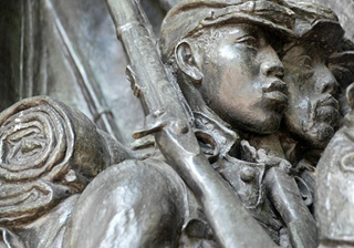 Photo of a metal relief sculpture of Civil War-era soldiers marching with rifles and gear. Photo of a metal relief sculpture of Civil War-era soldiers marching with rifles and gear.