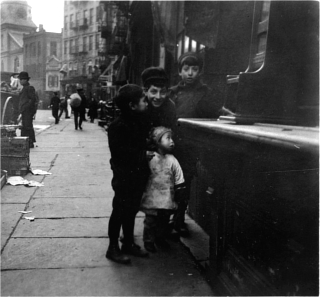 Black and white photo of two girls and two boys, standing in front of a shoeshine stand. Black and white photo of two girls and two boys, standing in front of a shoeshine stand.