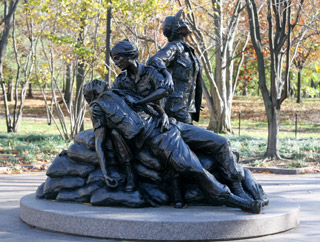 A bronze monument depicting a nurse tending to a wounded soldier, while another nurse looks towards the sky. A bronze monument depicting a nurse tending to a wounded soldier, while another nurse looks towards the sky.