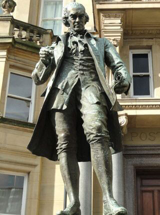 A statue of a formally-dressed man, wearing an overcoat and knee-high boots, holding a scroll in one hand, and compasses in the other. A statue of a formally-dressed man, wearing an overcoat and knee-high boots, holding a scroll in one hand, and compasses in the other.
