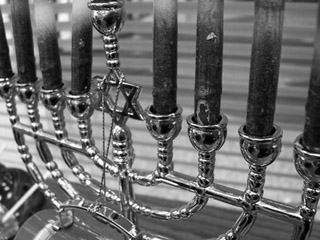 Black and white close-up photo of a menorah, the Star of David in its center. Black and white close-up photo of a menorah, the Star of David in its center.