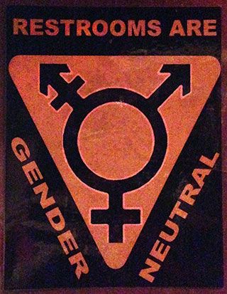 The words “Restrooms are gender neutral” surround a symbol featuring an “O” with an arrow and cross protruding from the top left, an arrow protruding from the top right, and a cross protruding from the bottom. The words “Restrooms are gender neutral” surround a symbol featuring an “O” with an arrow and cross protruding from the top left, an arrow protruding from the top right, and a cross protruding from the bottom.