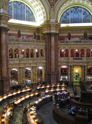 Photo of a large reading room at the Library of Congress, with several circular rows of tables around a central main desk. Photo of a large reading room at the Library of Congress, with several circular rows of tables around a central main desk.