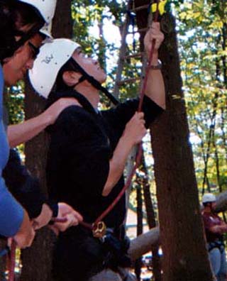 Photo of a student belaying on a ropes course. Photo of a student belaying on a ropes course.