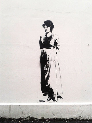 A black stencil of Mary Wollstonecraft painted on a white wall. A black stencil of Mary Wollstonecraft painted on a white wall.