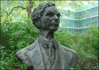 Green foliage surrounds a bust of a man. Green foliage surrounds a bust of a man.