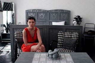 An image of a woman sitting in a black and white room. An image of a woman sitting in a black and white room.
